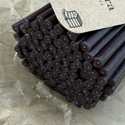 Black beeswax taper candles 6.3″, candle ends closeup in a bundle of 100