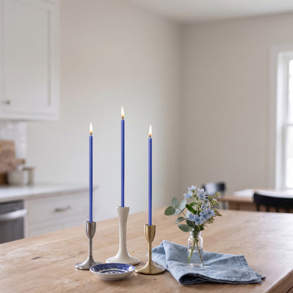 Blue beeswax taper candles 6.3″, lit in candlesticks interior