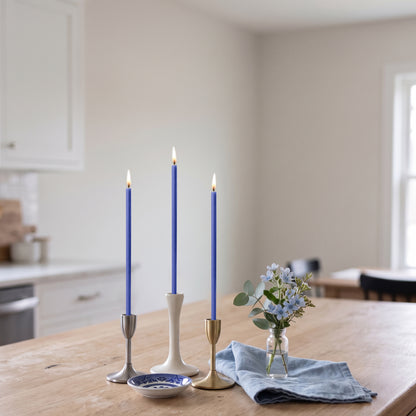 Blue beeswax taper candles 6.5″, lit in candlesticks interior