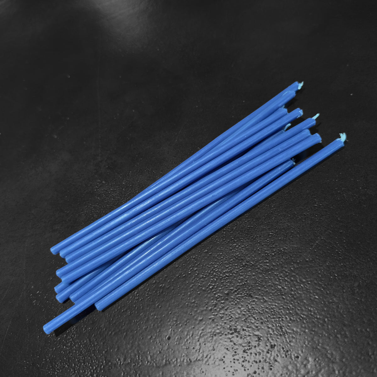Blue beeswax taper candles 7.3″, bundle on dark stone