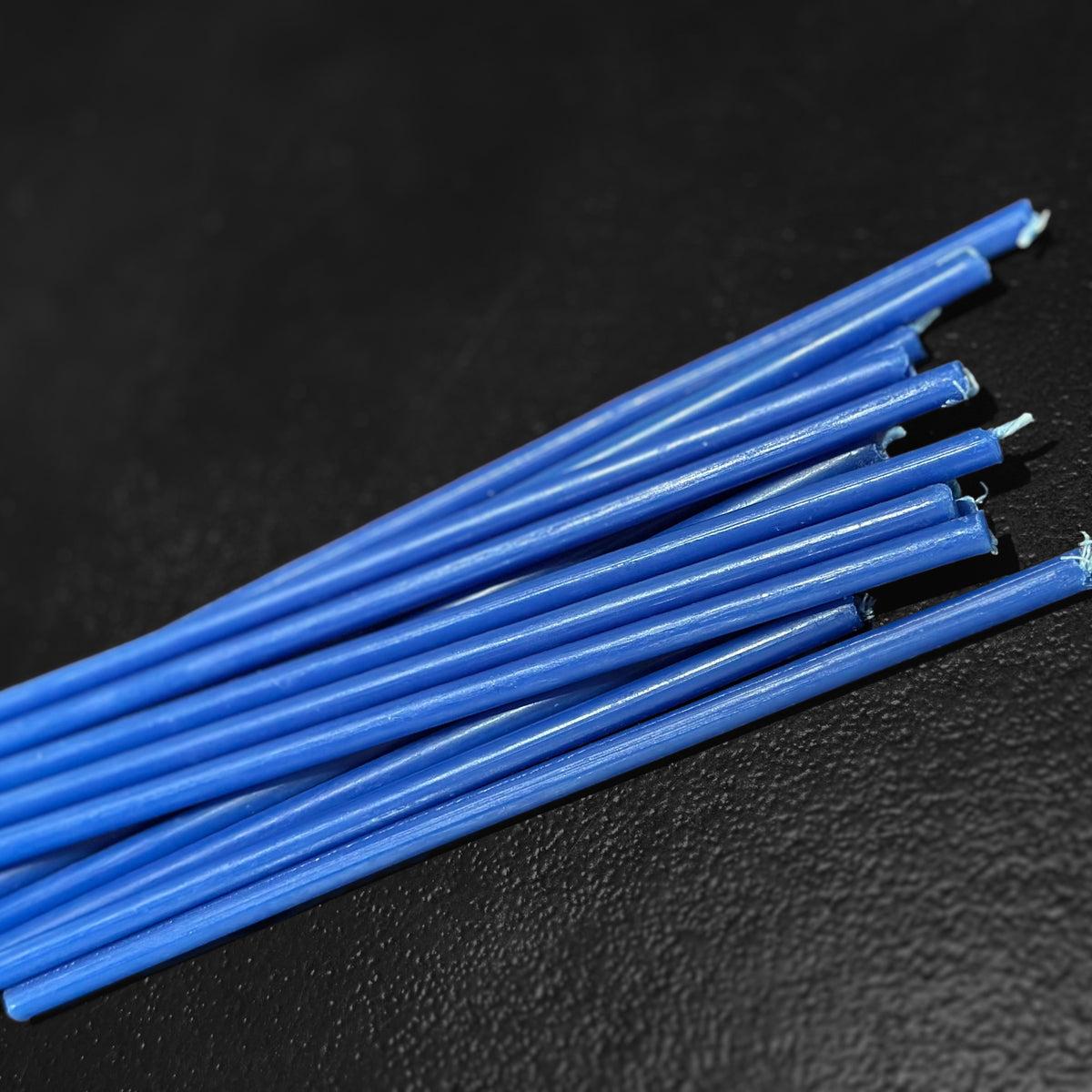 Blue beeswax taper candles 7.3″, closeup wicks on dark