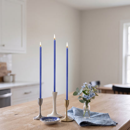 Blue beeswax taper candles 7.3″, lit in candlesticks interior
