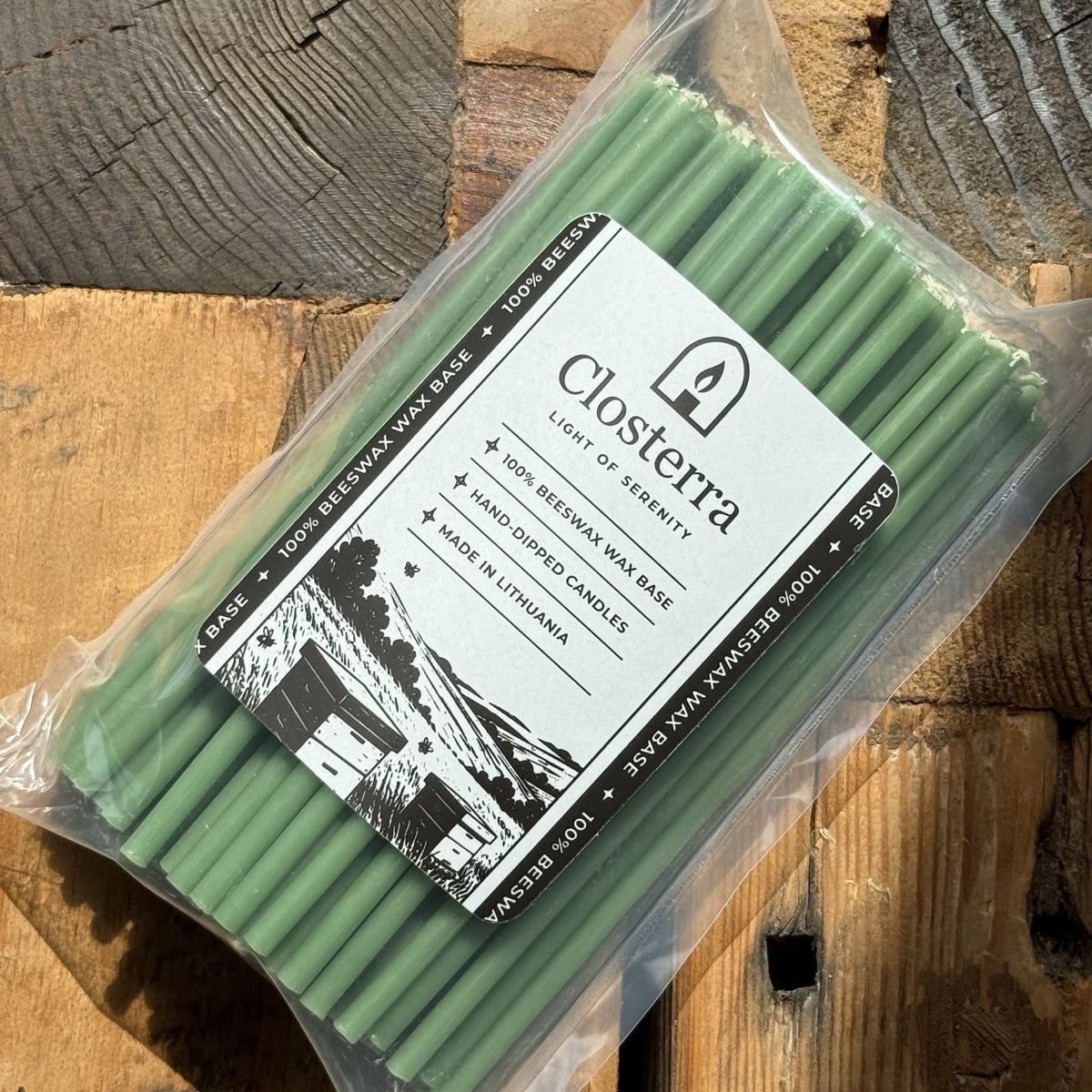 Green beeswax taper candles 6.3″, in Closterra packaging on rustic wood