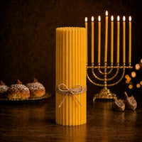 Closterra set of 90 tall natural beeswax Hanukkah candles beside a menorah