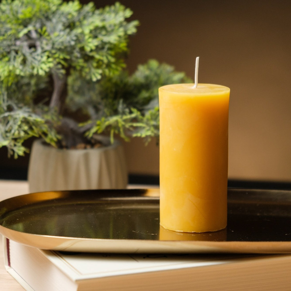 Natural beeswax pillar candle 2 by 4 inch, single candle on a gold tray