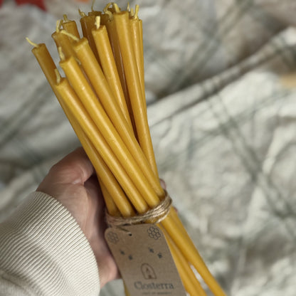 Natural yellow beeswax taper candles 11.6″, bundle of 20 held in hand