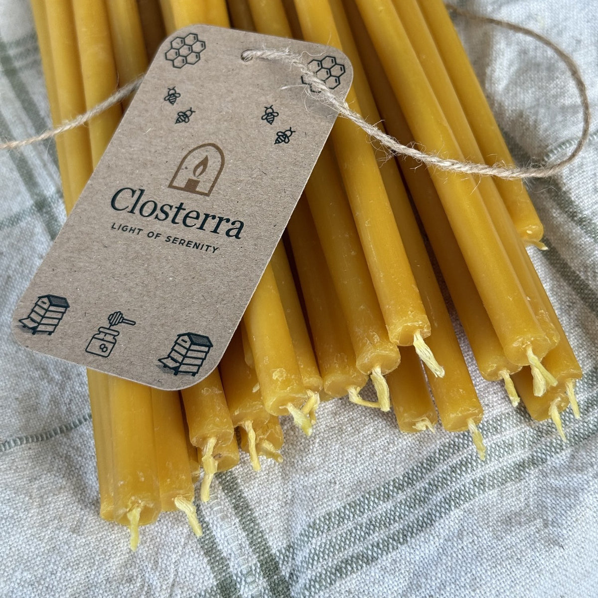 Natural yellow beeswax taper candles 11.6″, bundle of 20 with Closterra tag, closeup