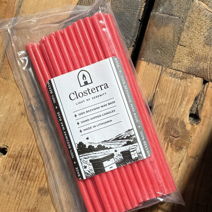 Red beeswax taper candles 7.3″, in Closterra packaging on rustic wood, close-up