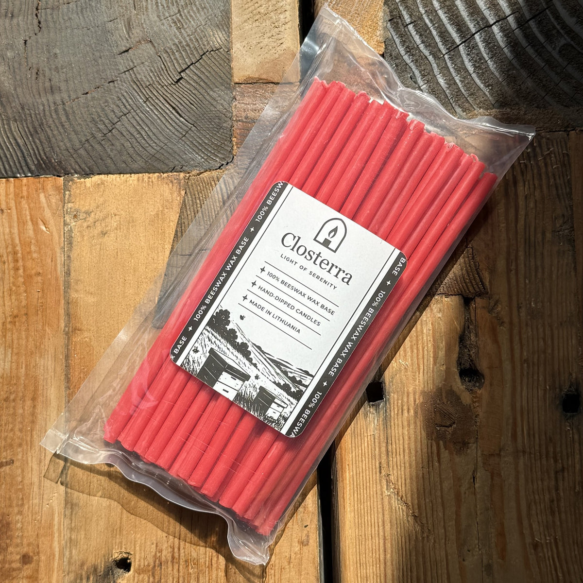Red beeswax taper candles 8″, in Closterra packaging on rustic wood