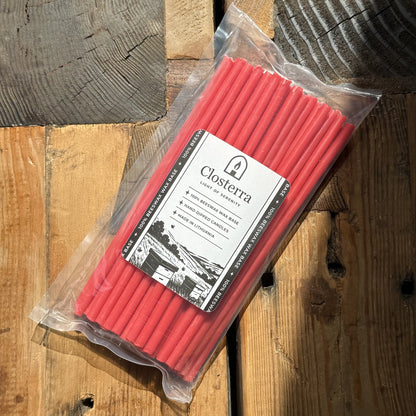Red beeswax taper candles 8″, in Closterra packaging on rustic wood