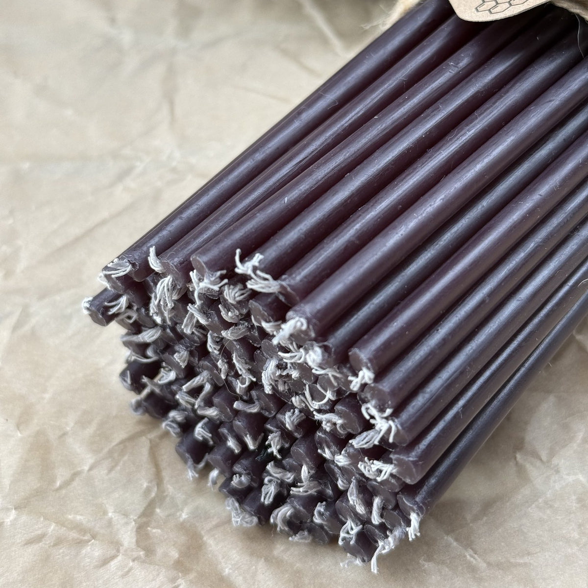Bundle of black beeswax ritual candles with cotton wicks, close-up