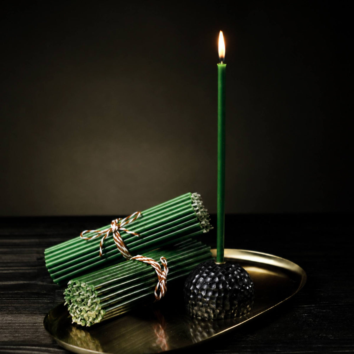Closterra thin green beeswax taper candles, lit on a tray