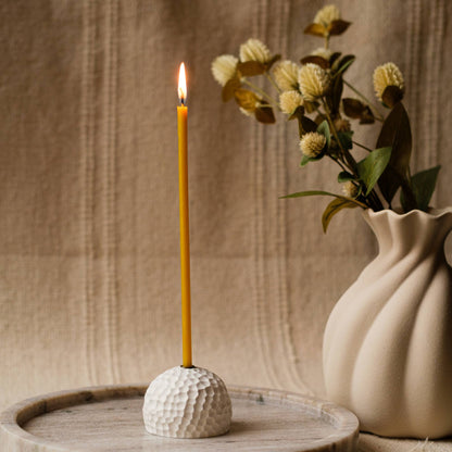 Closterra thin natural yellow beeswax taper candles, lit in a vase