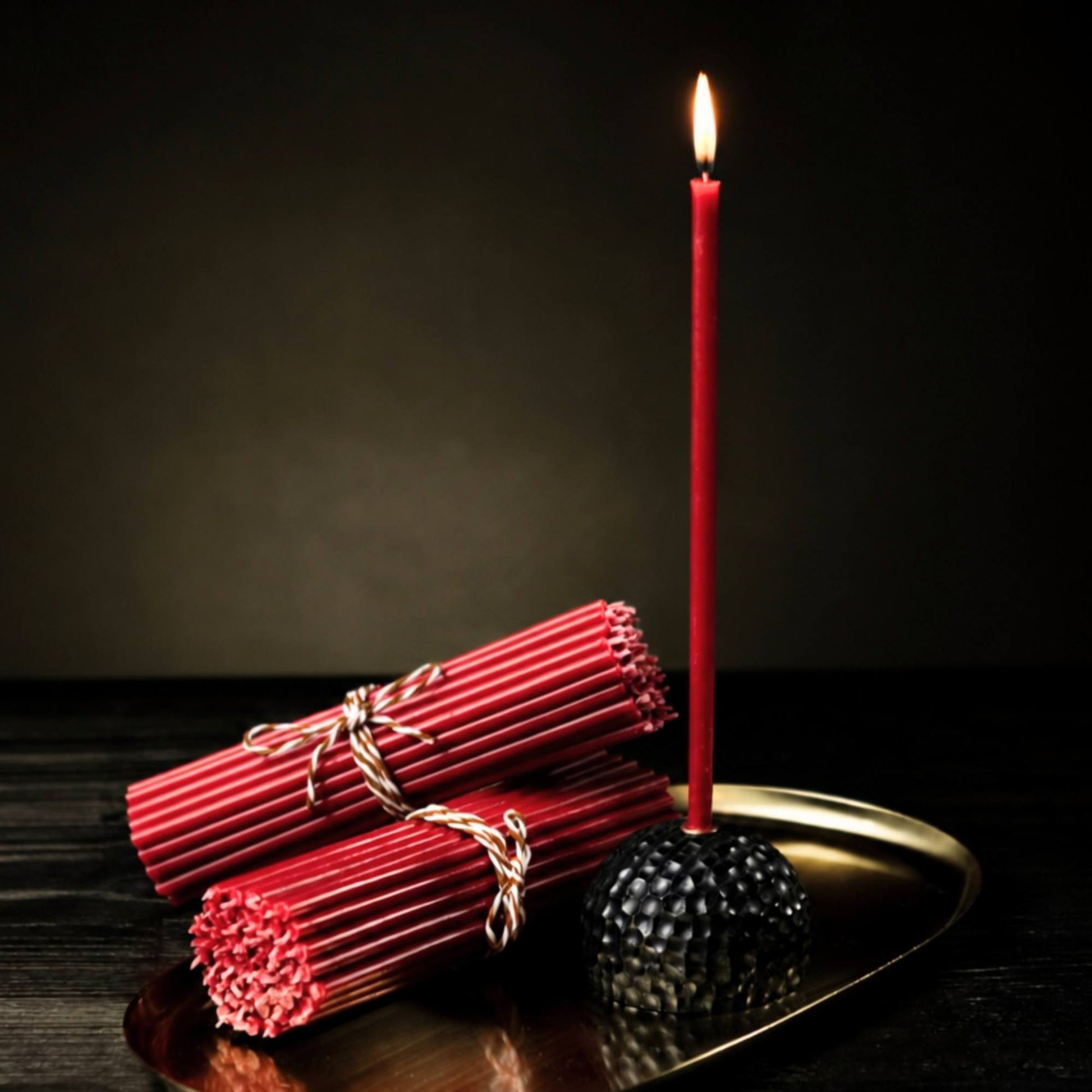 Closterra thin red beeswax taper candles, lit on a tray