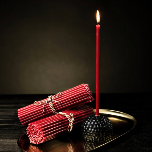 Closterra thin red beeswax taper candles, lit on a tray