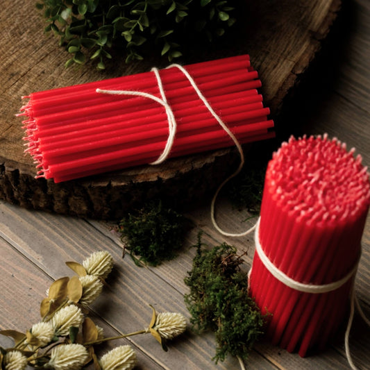 Closterra thin red beeswax taper candles, on a wood slice