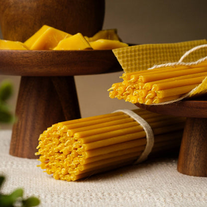 Closterra thin natural yellow beeswax taper candles, beside honeycomb