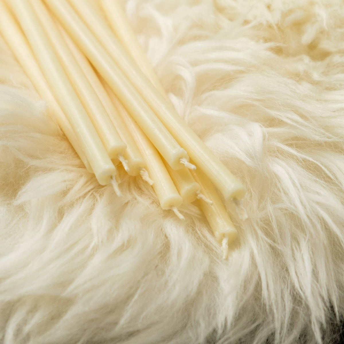 Closterra thin white beeswax taper candles, a close-up of the tapers