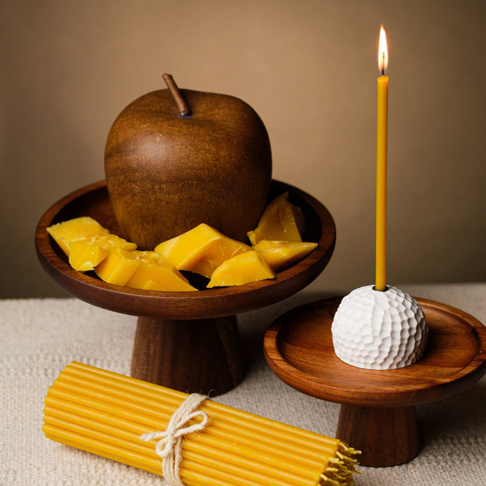 Closterra thin natural yellow beeswax taper candles, lit and styled on a table