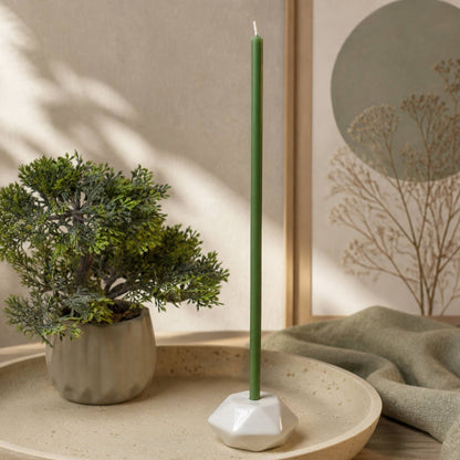 Closterra thin green beeswax taper candles, lit in a candle holder