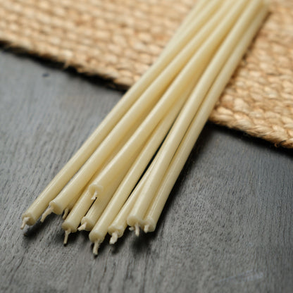 White beeswax taper candles 6.3″, loose tapers on dark wood and a jute mat