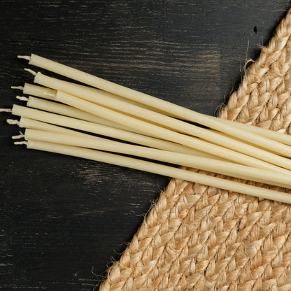 White beeswax taper candles 6.5″, loose tapers on dark wood and a jute mat