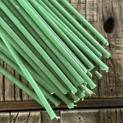 Green beeswax taper candles 7.3″, closeup on weathered wood