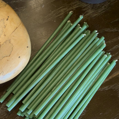 Green beeswax taper candles 7.3″, loose on dark table