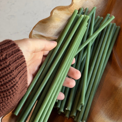 Green beeswax ritual candles 8″, held in hand