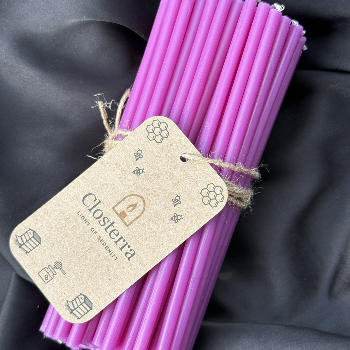 Purple beeswax taper candles 6.5″, bundle of 100 with Closterra tag on black satin