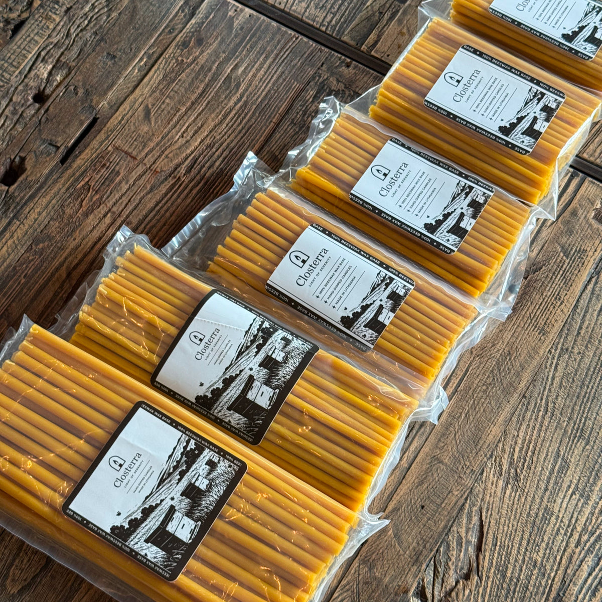 Natural beeswax taper candles 7.3″, packs lined on wood