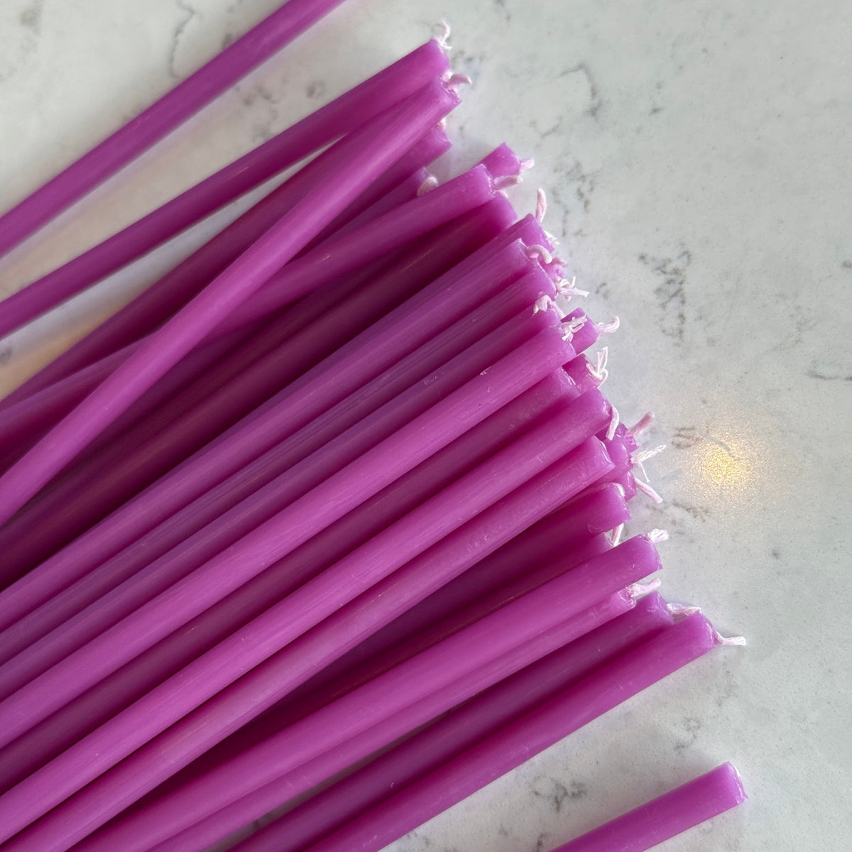 Purple beeswax taper candles 6.5″, closeup wicks on marble