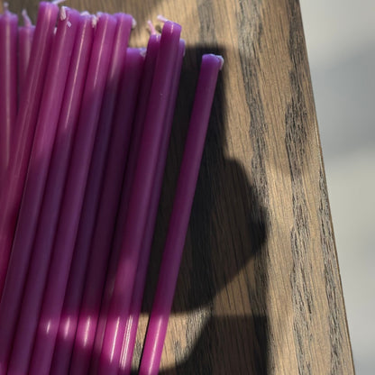 Purple beeswax taper candles 6.5″, closeup wicks on wood