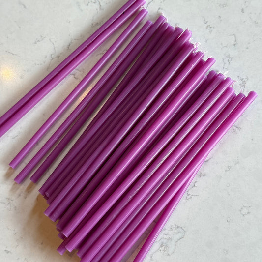 Purple beeswax taper candles 6.5″, fanned out on marble