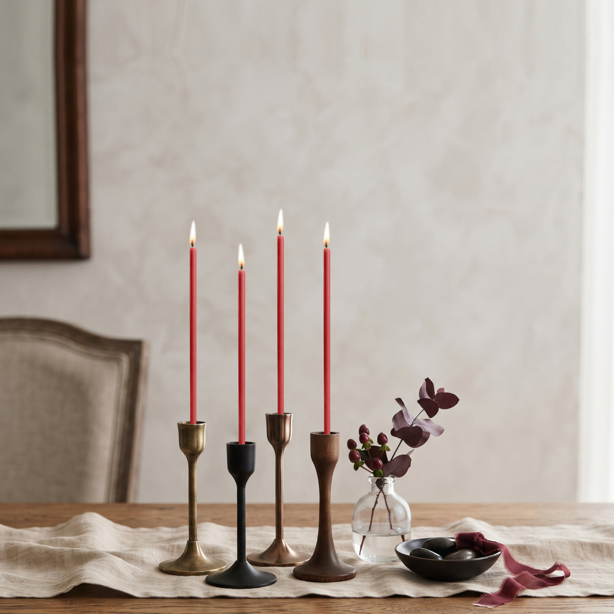 Red beeswax taper candles 6.3″, lit in mixed candlesticks