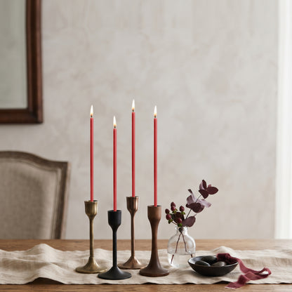 Red beeswax taper candles 6.3″, lit in mixed candlesticks