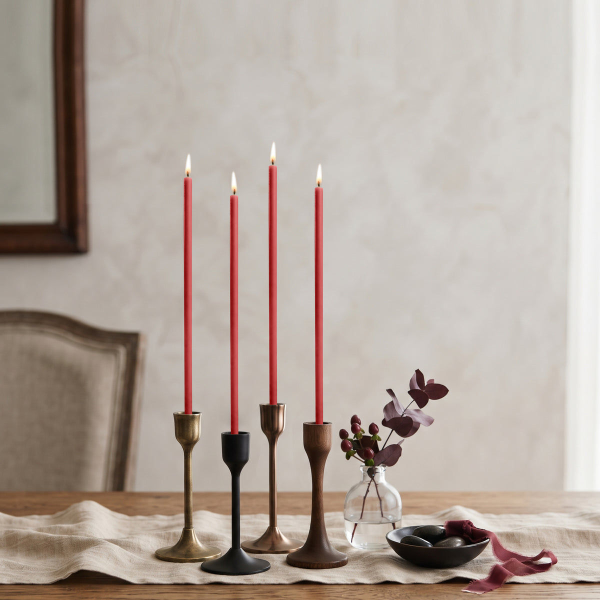 Red beeswax taper candles 7.3″, lit in mixed candlesticks