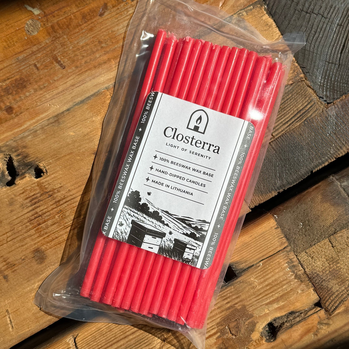Red beeswax taper candles 7.3″, single pack on wood